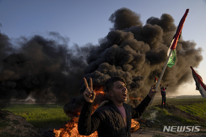 [제닌=AP/뉴시스] 26일(현지시간) 서안지구 제닌에서 팔레스타인 사람들이 타이어를 태우고 국기를 흔들며 이스라엘군의 공격 반대 시위를 하고 있다. 팔레스타인 당국은 이스라엘군이 제닌의 난민촌을 급습해 60세 여성 포함, 팔레스타인인 9명이 숨지고 최소 20명이 다쳤다고 밝혔다. 이스라엘군은 이 지역에서 무장세력 체포 작전 중이었다고 전했으며 아랍 연맹과 이집트 정부는 이스라엘 비난 성명을 발표했다. 2023.01.27.