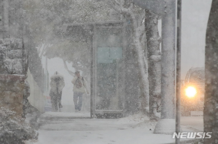 [제주=뉴시스] 우장호 기자 = 대설과 강풍특보가 내려지는 등 기상이 악화한 27일 오전 제주 시내 거리에서 시민들이 강한 눈보라 사이를 걸어가고 있다. 한국공항공사에 따르면 제주공항과 상대공항 기상 악화를 이유로 항공편 50여편 이상 결항조치 됐다. 2023.01.27. woo1223@newsis.com