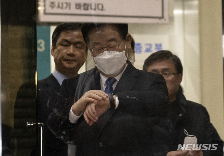 [서울=뉴시스] 김근수 기자 = 28일 밤 서울 서초구 서울중앙지검에서 이재명 더불어민주당 대표가 소환조사를 마치고 밖으로 나오면서 시계를 보고 있다. 2023.01.28. ks@newsis.com