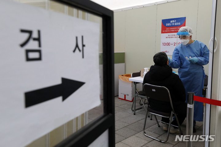 [서울=뉴시스] 백동현 기자 = 코로나19 신규 확진자가 1만8871명으로 집계된 지난달 29일 오후 서울 송파구 올림픽공원 평화의문 광장 임시선별검사소에서 의료진이 검체를 채취하고 있다. 2023.02.19. livertrent@newsis.com