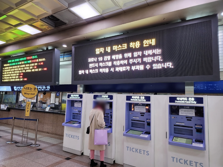 [수원=뉴시스] 박종대 기자 = 정부가 실내마스크 착용 의무를 권고로 전환한 첫날인 30일 오전 경기 수원시 수원역 대합실에서 열차권을 끊는 한 시민 위로 열차 내 마스크 착용 안내문이 고지되고 있다. 2023.01.30. pjd@newsis.com *재판매 및 DB 금지