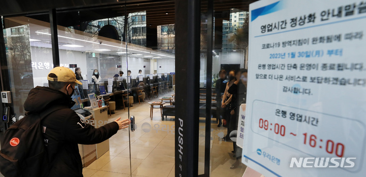 [서울=뉴시스] 백동현 기자 = 주요 시중은행과 저축은행들이 약 1년 반 만에 단축 영업을 중단하고 오전 9시에 문을 열기로 한 30일 오전 서울 시내 한 은행 지점에서 시민이 9시가 되자 오픈한 지점 안으로 들어가고 있다. 2023.01.30. livertrent@newsis.com