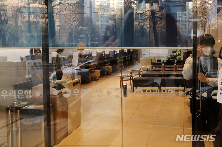 [서울=뉴시스] 백동현 기자 = 주요 시중은행과 저축은행들이 약 1년 반 만에 단축 영업을 중단하고 오전 9시에 문을 열기로 한 30일 오전 서울 시내 한 은행 지점에서 은행 관계자가 9시가 되자 오픈을 위해 커튼을 올리고 있다. 2023.01.30. livertrent@newsis.com