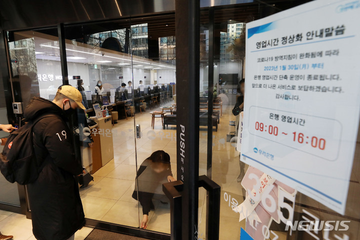 [서울=뉴시스] 백동현 기자 = 주요 시중은행과 저축은행들이 약 1년 반 만에 단축 영업을 중단하고 오전 9시에 문을 열기로 한 30일 오전 서울 시내 한 은행 지점에서 시민이 9시가 되자 오픈한 지점 안으로 들어가고 있다. 2023.01.30. livertrent@newsis.com