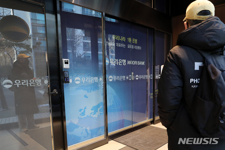 [서울=뉴시스] 백동현 기자 = 주요 시중은행과 저축은행들이 약 1년 반 만에 단축 영업을 중단하고 오전 9시에 문을 열기로 한 30일 오전 서울 시내 한 은행 지점에서 시민이 오픈을 기다리고 있다. 2023.01.30. livertrent@newsis.com