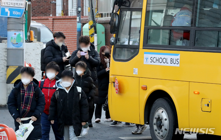 [서울=뉴시스] 지난 1월30일 오전 서울 광진구 광장초등학교 앞에 정차한 스쿨버스에서  마스크를 착용한 학생들이 내리고 있다. (공동취재사진) 2023.03.15. photo@newsis.com