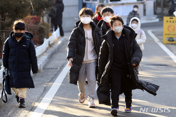 [서울=뉴시스] 최진석 기자 = 일부 시설을 제외한 실내에서 마스크 착용 의무가 해제된 30일 오전 서울 광진구 광장초등학교에서 마스크를 착용한 학생들이 등교하고 있다. (공동취재사진) 2023.01.29. photo@newsis.com