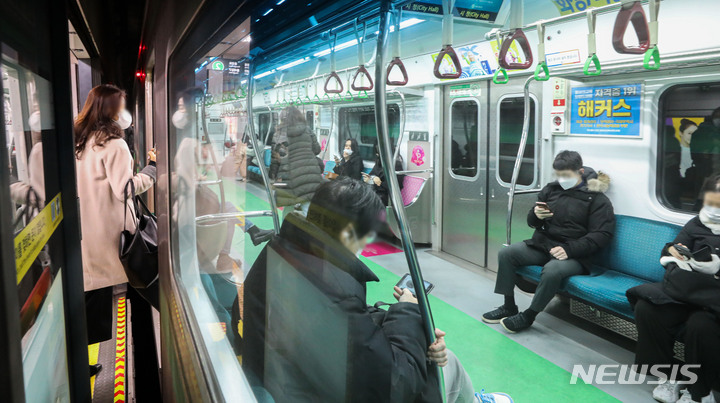 [서울=뉴시스] 권창회 기자 = 대중교통, 병원 등 일부 시설을 제외한 실내에서 마스크 착용 의무가 해제된 30일 오전 서울 중구 시청역에서 시민들이 마스크를 착용한 채 열차에 탑승해 있다. 2023.01.30. kch0523@newsis.com