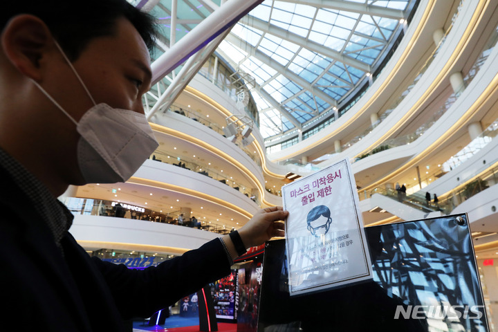 [서울=뉴시스] 백동현 기자 = 서울 시내 한 쇼핑몰에서 관계자가 기존에 게재되어 있던 '마스크 미착용시 출입 제한' 안내문을 떼어내고 있다. 2023.01.30. livertrent@newsis.com