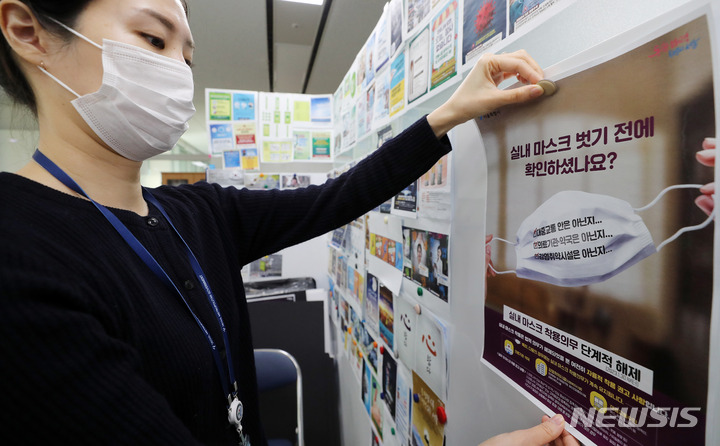 [서울=뉴시스] 백동현 기자 = 감염취약시설과 대중교통 등을 제외한 대부분의 시설에서 실내 마스크 착용 의무화가 해제된 30일 오후 서울시청 소통전략팀 사무실에서 직원이 새롭게 제작한 실내 마스크 관련 안내문을 붙이고 있다. 2023.01.30. livertrent@newsis.com