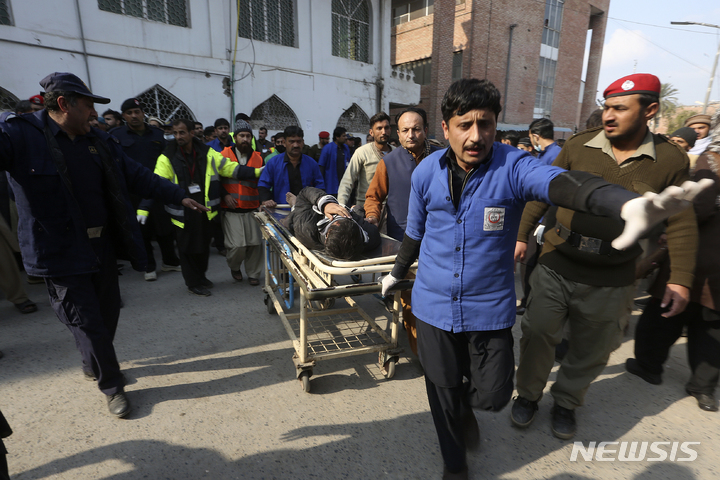 [페샤와르=AP/뉴시스] 30일(현지시간) 파키스탄 페샤와르의 한 이슬람 사원과 경찰서 부근에서 자살폭탄 테러가 발생,&nbsp; 한 병원에서 부상당한 피해자를 의료진이 옮기고 있다. 페샤와르의 이슬람사원 자살폭탄테러로 최소 34명이 숨지고 150명이 넘는 부상자가 발생했다고 파키스탄 경찰은 밝혔다. 2023.01.30.
