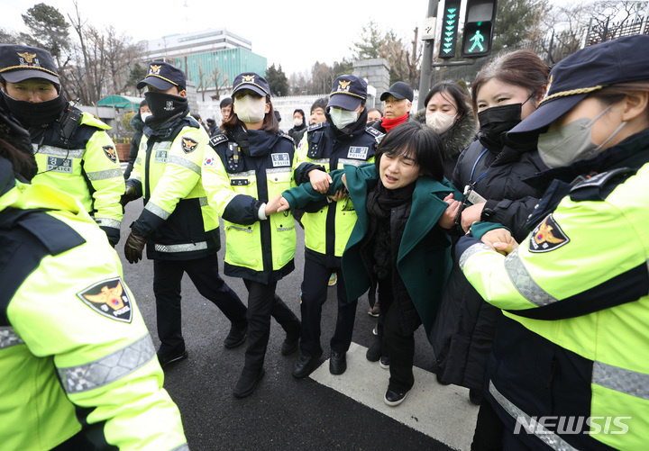 [서울=뉴시스] 김진아 기자 = 10.29 이태원 참사로 숨진 故 이지한 씨의 어머니 조미은 씨와 아버지 이종철 씨가 31일 서울 용산구 대통령 집무실 앞에서 면담 등을 요구하며 진입을 시도하다 제지당하고 있다. 2023.01.31. bluesda@newsis.com