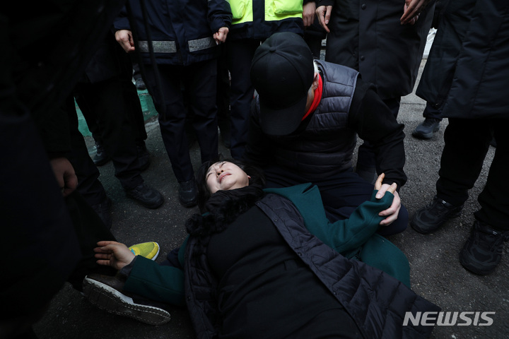 [서울=뉴시스] 김진아 기자 = 10.29 이태원 참사로 숨진 故 이지한 씨의 어머니 조미은 씨와 아버지 이종철 씨가 31일 서울 용산구 대통령 집무실 앞에서 면담 등을 요구하며 진입을 시도하다 제지당하고 있다. 2023.01.31. bluesda@newsis.com