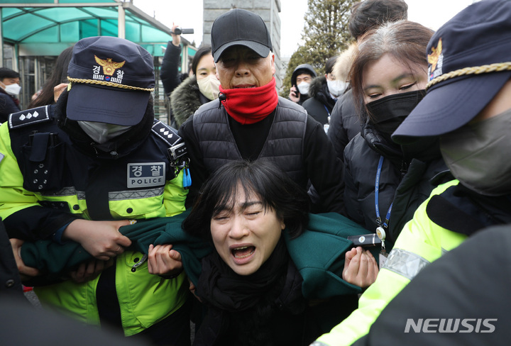 [서울=뉴시스] 김진아 기자 = 10.29 이태원 참사로 숨진 故 이지한 씨의 어머니 조미은 씨와 아버지 이종철 씨가 31일 서울 용산구 대통령 집무실 앞에서 면담 등을 요구하며 진입을 시도하다 제지당하고 있다. 2023.01.31. bluesda@newsis.com