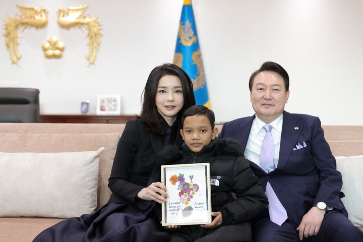 [서울=뉴시스] 윤석열 대통령과 부인 김건희 여사가 31일 서울 용산 대통령실 청사에서 캄보디아 소년 로타와 기념촬영하고 있다. (사진=대통령실 제공) 2023.01.31. photo@newsis.com *재판매 및 DB 금지