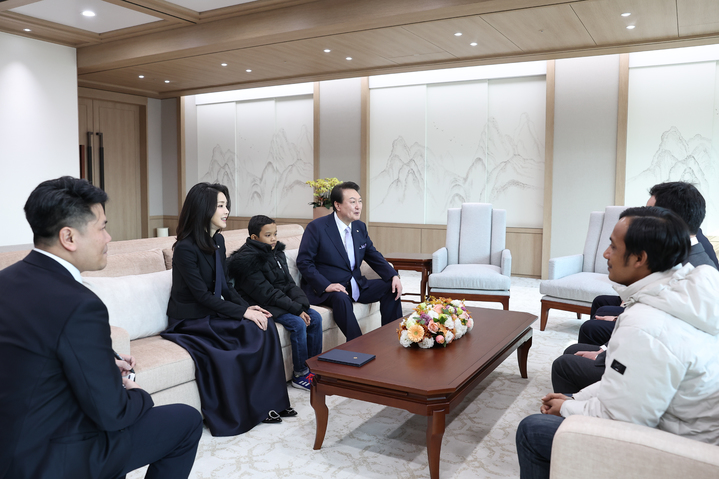 [서울=뉴시스] 윤석열 대통령과 부인 김건희 여사가 31일 서울 용산 대통령실 청사에서 캄보디아 소년 로타를 만나 관계자들과 대화하고 있다. (사진=대통령실 제공) 2023.01.31. photo@newsis.com *재판매 및 DB 금지