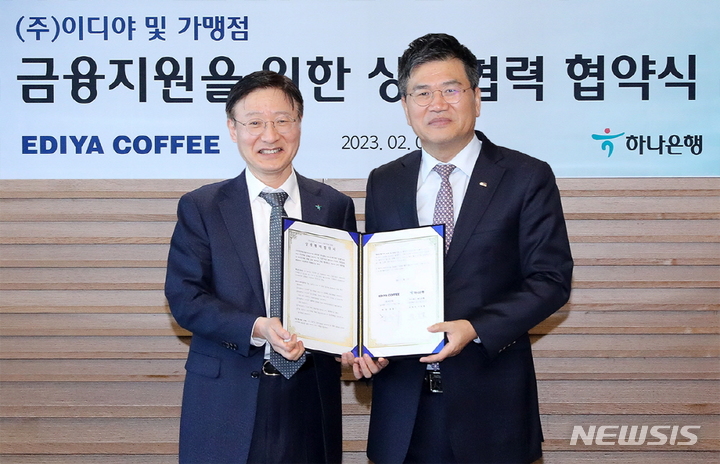 [서울=뉴시스]1일 서울시 중구 을지로에 위치한 하나은행 본점에서 열린 ‘이디야커피 가맹점 금융지원을 위한 상생협력 협약식’에서 문창기 이디야커피 회장(오른쪽)과 이승열 하나은행장이 기념촬영을 하고 있다.(사진=이디야 제공)