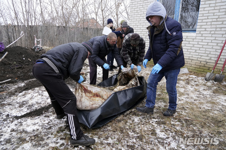 [보로바=AP/뉴시스] 1일(현지시간) 우크라이나 하르키우주 보로바에서 장례 관계자들이 지난해 4월 14일 피난 중 러시아군에게 살해돼 이 마을 병원 땅에 묻혔던 한 주민의 시신을 발굴해 옮기고 있다. 우크라이나 경찰과 전범조사국은 당시 미니밴 2대로 피난 도중 러시아군에 살해돼 매장된 주민들에 대한 발굴조사를 시행했다. 2023.02.03.