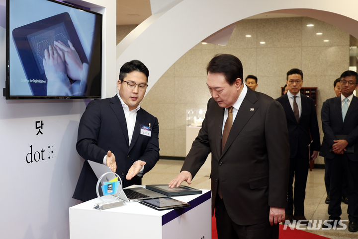 [서울=뉴시스] 홍효식 기자 = 윤석열 대통령이 2일 서울 용산 대통령실 청사에서 열린 국제전자제품박람회(CES) 디지털 기술혁신 기업인과의 오찬 간담회에 앞서 2023 CES 최고 혁신상을 수상한 '닷' 부스를 방문해 시각장애인용 촉각 패드를 살펴보고 있다. 닷 촉각 패드는 시각장애인을 위한 세계 최초의 촉각 그래픽 장치로 사진 및 동영상을 인공지능(AI)으로 분석해 점자 형태로 제공한다. (대통령실통신사진기자단) 2023.02.02. yesphoto@newsis.com