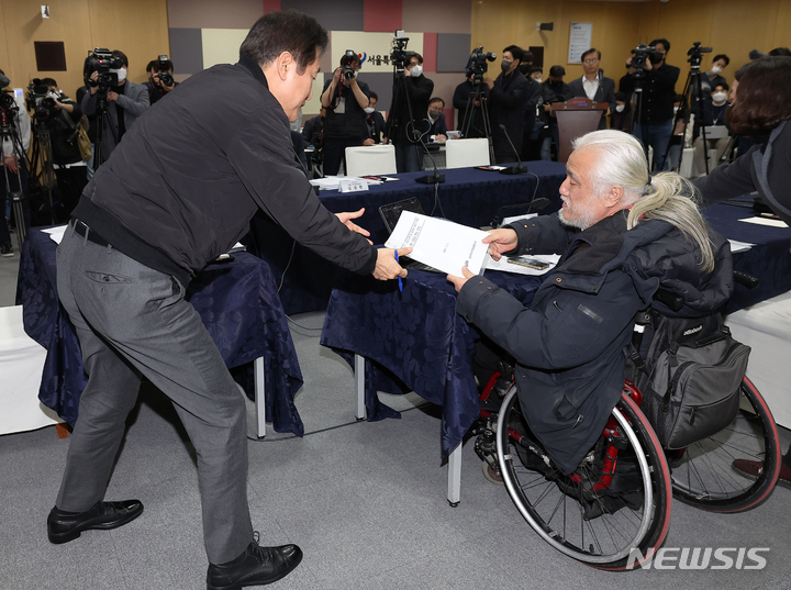 [서울=뉴시스] 김금보 기자 = 오세훈 서울시장이 2일 서울 중구 서울시청에서 열린 간담회에서 박경석 전국장애인차별철폐연대 상임공동대표에게 자료를 전달받고 있다. (공동취재사진) 2023.02.02. photo@newsis.com