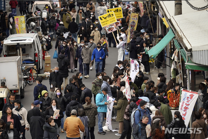 [도쿄=AP/뉴시스]지난 2일 점심시간에 일본 도쿄 쓰키지 시장 골목길을 따라 내외국인 방문객들이 간식을 사기 위해 줄 서 있다. 2023.02.24.