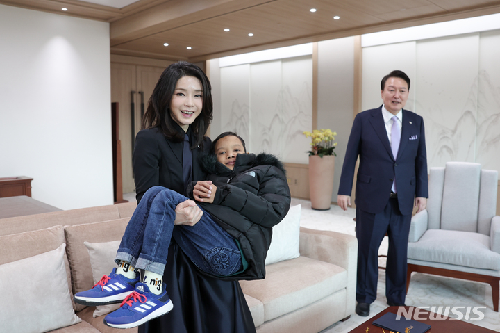 [서울=뉴시스] 윤석열 대통령 부인 김건희 여사가 31일 서울 용산 대통령실 청사에서 캄보디아 소년 로타를 안고 있다. (사진=대통령실 제공) 2023.01.31. photo@newsis.com *재판매 및 DB 금지