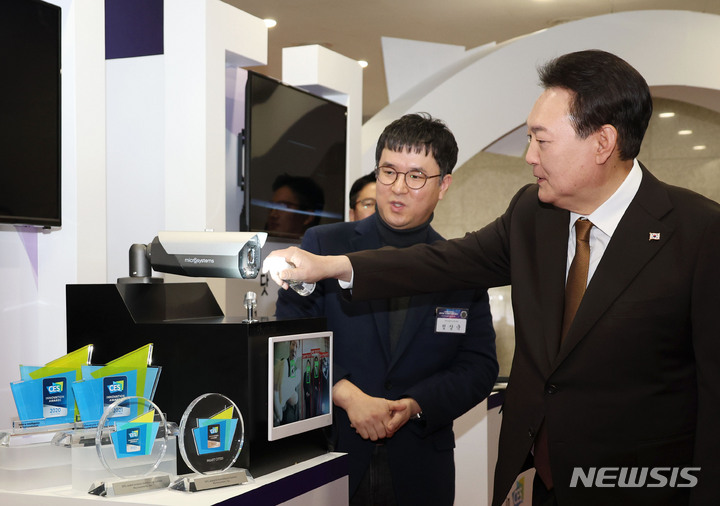 [서울=뉴시스] 홍효식 기자 = 윤석열 대통령이 2일 서울 용산 대통령실 청사에서 열린 국제전자제품박람회(CES) 디지털 기술혁신 기업인과의 오찬 간담회에 앞서 2023 CES 최고 혁신상을 수상한 '마이크로시스템' 부스를 방문해 전자식 자가세정 기술이 적용된 지능형 CCTV를 시연해보고 있다. 자가세정 지능형 CCTV는 전자식 자가세정 기술이 최초로 적용돼 태풍과 같은 기상재해 환경에서도 선명한 고화질로 실시간 영상 감시가 가능하다. (대통령실통신사진기자단) 2023.02.02. yesphoto@newsis.com