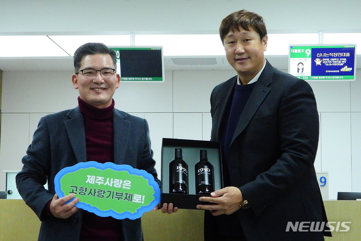 [제주=뉴시스] 우장호 기자 = 이대호(41·전 롯데자이언츠)씨가 3일 오후 제주시 NH농협은행 연북로지점에서 고향사랑기부제에 동참한 후 윤재춘(왼쪽) 농협 제주지역본부장으로부터 감귤 와인을 선물로 받고 있다. 2023.02.03. woo1223@newsis.com