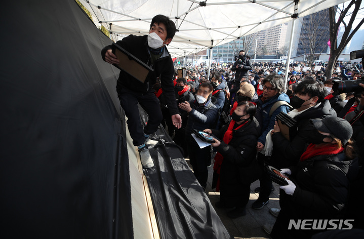 [서울=뉴시스] 김진아 기자 = '10.29 이태원 참사 추모대회'를 위해 광화문으로 행진을 하던 유가족과 시민들이 4일&nbsp; 서울 중구 서울광장에 10·29 이태원 참사 분향소를 설치하고 있다. 2023.02.04. bluesda@newsis.com