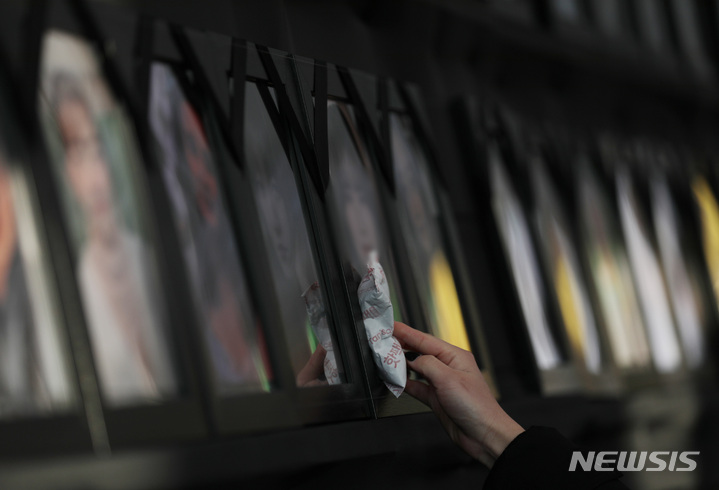 [서울=뉴시스] 김진아 기자 = 10·29 이태원참사 유가족이 4일&nbsp; 서울 중구 서울광장에 설치된 10·29 이태원 참사 분향소에서 영정사진에 핫팩을 올려두고 있다. 2023.02.04. bluesda@newsis.com