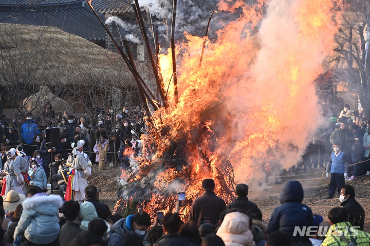 [용인=뉴시스] 김종택 기자 = 5일 오후 경기도 용인 한국민속촌에서 열린 정월대보름 달집태우기 행사에서 시민들이 활활 타오르는 달집을 바라보며 풍요와 무사안녕을 기원하고 있다. 2023.02.05. jtk@newsis.com