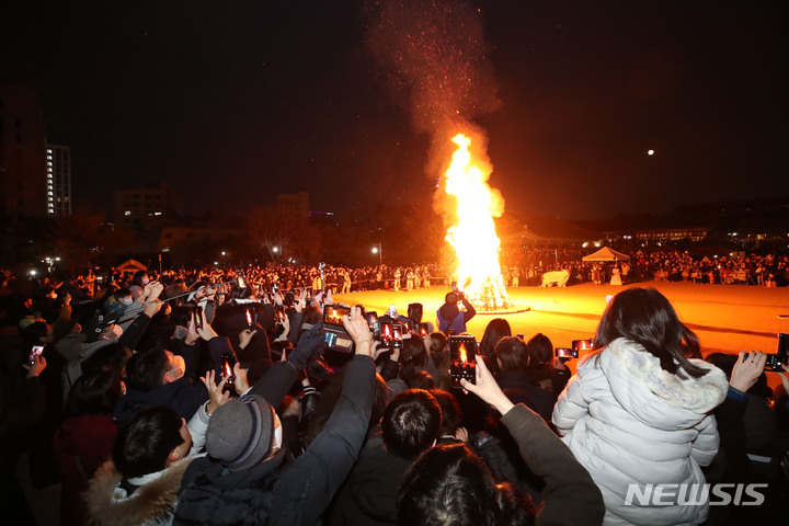 [서울=뉴시스] 조수정 기자 = 정월대보름인 5일 서울 중구 남산골한옥마을 천우각 광장에서 많은 시민들이 지신밟기와 달집태우기 행사를 보며 보름달과 달집을 휴대전화 카메라로 촬영하고 있다. 2023.02.05. chocrystal@newsis.com