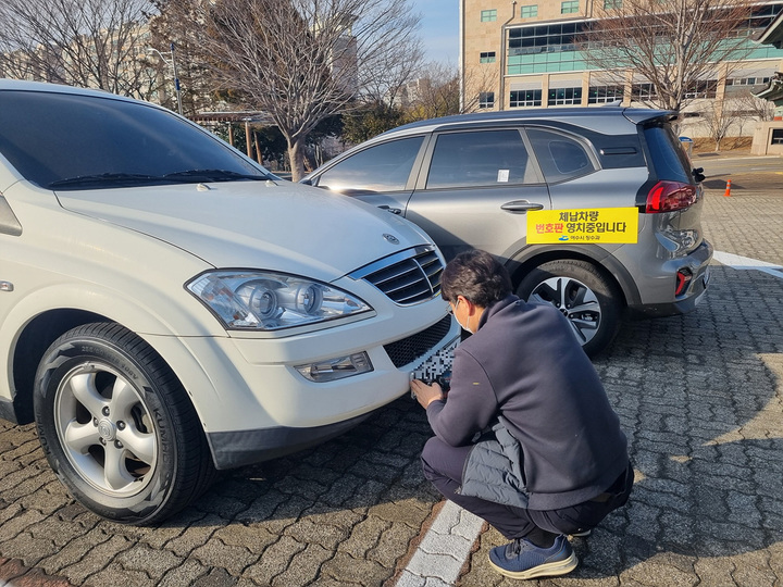 여수시 공무원이 체납 차량을 찾아내 번호판을 영치하고 있다. 여수시 제공 *재판매 및 DB 금지