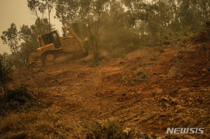 [산타후아나=AP/뉴시스] 5일(현지시간) 칠레 산타 후아나에서 불도저 한 대가 산불의 확산을 막기 위해 나무를 밀어내고 있다. 지난 3일 칠레 중남부에서 발생한 산불이 번지면서 지금까지 최소 23명이 숨지고 긴급 대피령 등이 내려졌다. 2023.02.06.