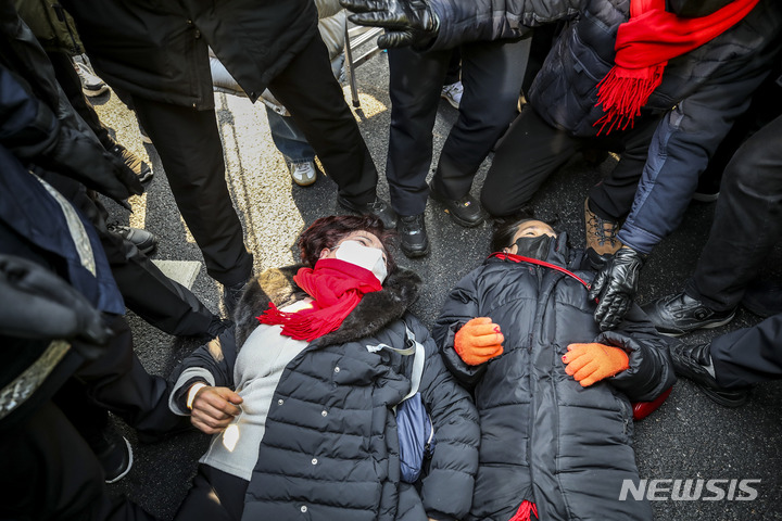 [서울=뉴시스] 정병혁 기자 = 6일 오전 서울 중구 서울광장에 설치된 이태원참사 분향소에서 유가족들이 시청 진입을 시도하던 도중 도로에 누워있다. 2023.02.06. jhope@newsis.com