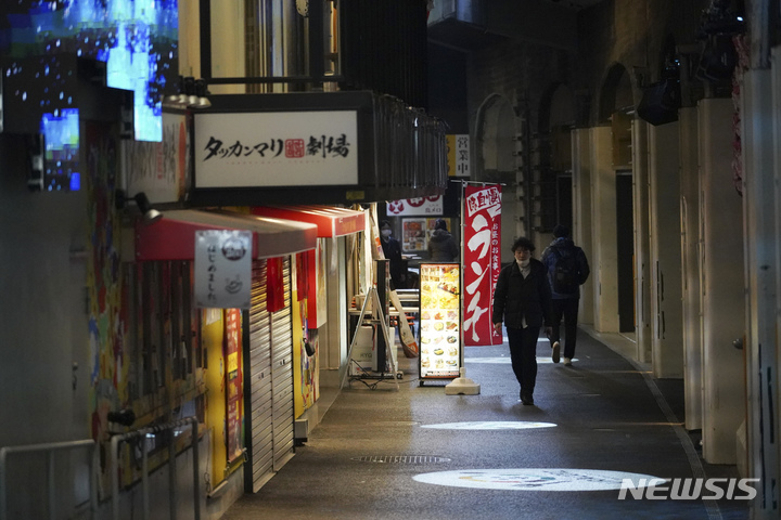 [도쿄=AP/뉴시스]지난 6일 점심 시간에 일본 도쿄에서 식당이 늘어선 복도를 사람들이 걷고 있다. 2023.02.23.