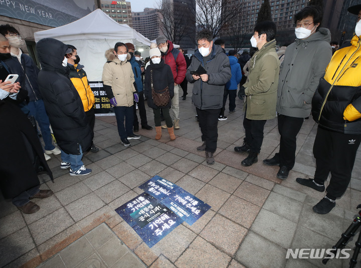 [서울=뉴시스] 조수정 기자 = 6일 오후 서울광장에 설치된 10·29 이태원 참사 분향소 앞에서 서울시 관계자가 시민대책회의와 유가족 측에 전달하려다 바닥에 떨어진&nbsp; 분향소 철거 서울시 행정대집행 2차 계고서가 손팻말로 덮여져 있다. 2023.02.06. chocrystal@newsis.com