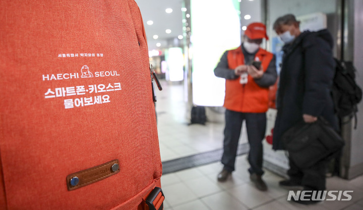 [서울=뉴시스] 정병혁 기자 = 7일 오전 서울 중구 서울역에서 디지털 안내사가 한 시민에게 스마트폰 사용법을 안내하고 있는 모습. 2023.02.07. jhope@newsis.com