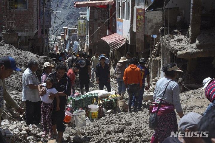 [카마나=AP/뉴시스] 7일(현지시간) 페루 카마나에서 주민들이 산사태 잔해로 뒤덮인 거리를 걷고 있다. 페루 당국은 지난 주말 폭우로 인해 발생한 산사태의 사망자 숫자가 40명으로 늘었다고 밝혔다. 2023.02.08.