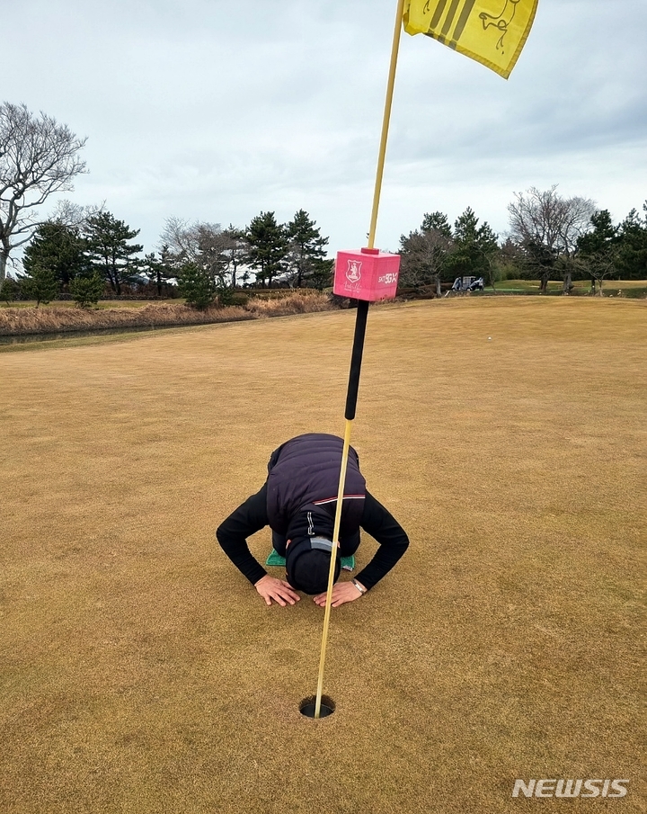 [제주=뉴시스] 홀인원에 성공한 김문기씨가 홀컵에 절을 하고 있다.