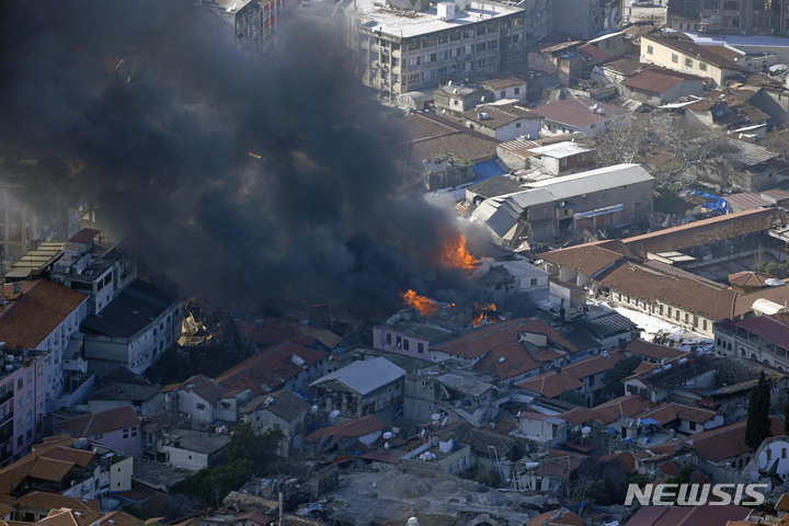 [안타키아=AP/뉴시스] 8일(현지시간) 지진으로 파괴된 튀르키예 남부 안타키아의 한 건물에서 연기와 화염이 치솟고 있다. 튀르키예와 시리아를 강타한 지진으로 사망자 숫자가&nbsp; 1만2천 명을 넘은 것으로 나타났으며 생존자를 구할 수 있는 골든 타임이 얼마 남지 않은 상황에서 강추위로 어려움이 가중되고 있다. 2023.02.09.