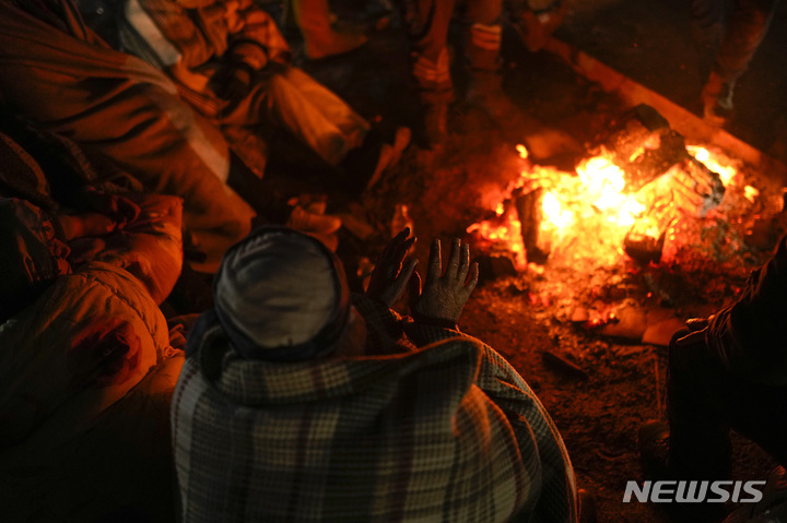 [엘비스탄=AP/뉴시스] 8일(현지시간) 튀르키예 남부 엘비스탄 지진 피해 현장에서 한 가족이 모닥불로 몸을 녹이고 있다. 2023.02.09.