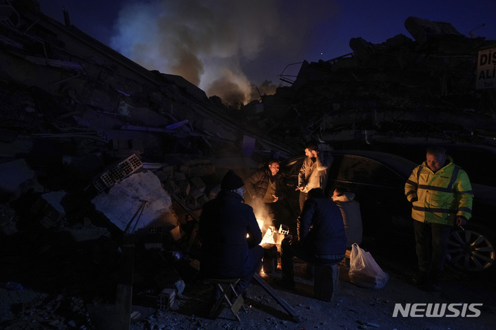 [안타키아=AP/뉴시스] 8일(현지시간) 튀르키예 남동부 안타키아 지진 피해 현장에서 시민이 모닥불로 몸을 녹이고 있다. 2023.02.09.