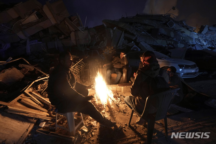 [안타키아=AP/뉴시스] 8일(현지시간) 튀르키예 남동부 안타키아 지진 피해 현장에서 시민들이 모닥불로 몸을 녹이고 있다. 2023.02.09.