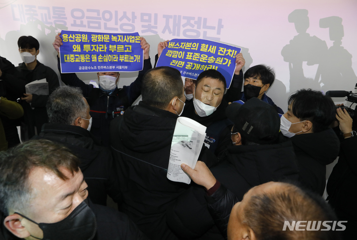 [서울=뉴시스] 고승민 기자 = 공공운수노조 민주버스본부 서울지부 회원들이 10일 서울시청 서소문청사 후생동에서 열린 '대중교통 요금인상 및 재정난 해소방안 논의를 위한 시민공청회' 시작 전 무대로 올라와 요금인상 반대 및 무상교통 등을 주장하다 찬성하는 참석자들과 마찰을 빚고 있다. 2023.02.10. kkssmm99@newsis.com