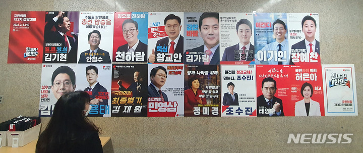 [서울=뉴시스] 전진환 기자 = 국민의힘 3·8 전당대회 전국 권역별 첫 합동연설회가 제주에서 열리는 13일 오전 서울 여의도 국회 본관 복도에서 한 국회 직원이 당 대표 후보 및 청년최고위원, 최고위원 후보들의 홍보물을 살펴보고 있다. 2023.02.13. amin2@newsis.com
