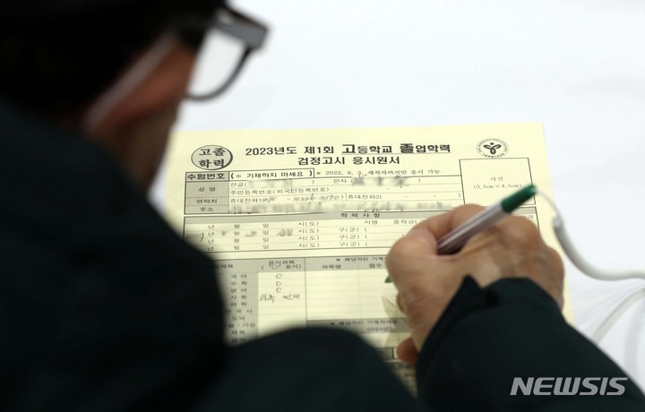 [서울=뉴시스] 조성봉 기자 = 13일 오전 서울 동작구 서울공업고등학교 체육관에 마련된 2023년도 1회 초졸·중졸·고졸 검정고시 시행 원서교부 및 접수처에서 한 어르신이 원서를 쓰고 작성하고 있다. 2023.02.13. suncho21@newsis.com
