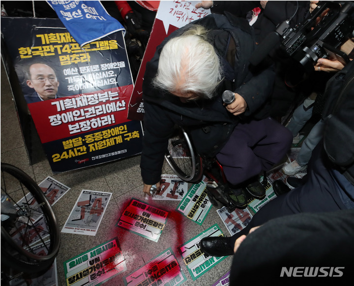 [서울=뉴시스] 조수정 기자 = 전국장애인차별철폐연대(전장연)가 13일 오전 서울 삼각지역 승강장 앞에서 '시민과 함께하는 달보기 운동' 선언 기자회견을 마친 뒤 승강장 바닥에 부착한 선전물이 비가 오면 미끄러우니 떼라는 지하철 공사 측의 요청에 락카로 '미끄럼 주의' 문구를 써놓으려다 제지하는 지하철공사 직원들과 몸싸움을 하고 있다. 전장연은 3월 23일까지 출근길 지하철 타기 선전전을 하지 않고 기획재정부가 3월 국가재정전략회의에서 2024년 정부 예산 가이드라인을 편성할 때 장애인 권리예산이 의미있는 수준으로 반영할 것을 촉구하며 기재부 장관이 적극적으로 대화에 나서기를 기다리겠다고 밝혔다. 2023.02.13. chocrystal@newsis.com