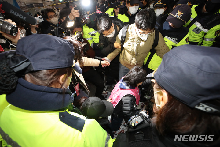 [서울=뉴시스] 조수정 기자 = 전국장애인차별철폐연대(전장연)가 13일 오전 서울 삼각지역 승강장 앞에서 '시민과 함께하는 달보기 운동' 선언 기자회견을 마친 뒤 승강장 바닥에 부착한 선전물이 비가 오면 미끄러우니 떼라는 지하철 공사 측의 요청에 락카로 '미끄럼 주의' 문구를 써놓으려다 제지하는 지하철공사 직원들과 몸싸움을 하고 있다. 전장연은 3월 23일까지 출근길 지하철 타기 선전전을 하지 않고 기획재정부가 3월 국가재정전략회의에서 2024년 정부 예산 가이드라인을 편성할 때 장애인 권리예산이 의미있는 수준으로 반영할 것을 촉구하며 기재부 장관이 적극적으로 대화에 나서기를 기다리겠다고 밝혔다. 2023.02.13. chocrystal@newsis.com