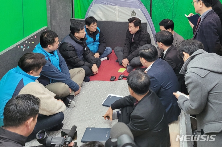 [제주=뉴시스] 이정민 기자 = 오영훈 제주도지사와 제주시 봉개동 소재 제주북부광역환경관리센터(북부소각장) 노동자, 민주노총 제주본부 관계자 등이 지난해 2월14일 제주도청 앞 천막농성장에서 이야기를 나누고 있다. 북부광역환경관리센터 운영 용역업체와 계약이 이달 말로 끝남에 따라 노동자들은 소각장 실제 운영자인 제주도에 고용승계를 요구하며 100일째 천막 농성을 벌이고 있다. 2023.02.14. 73jmlee@newsis.com